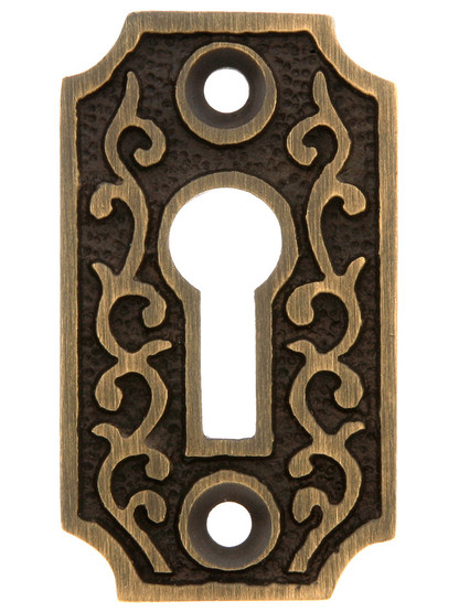 Solid Brass Scroll Keyhole Cover in Antique Brass.